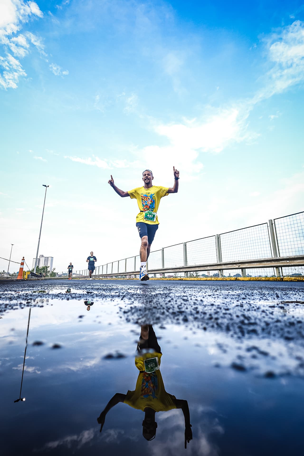 Corredor atravessando uma poça, refletido na água