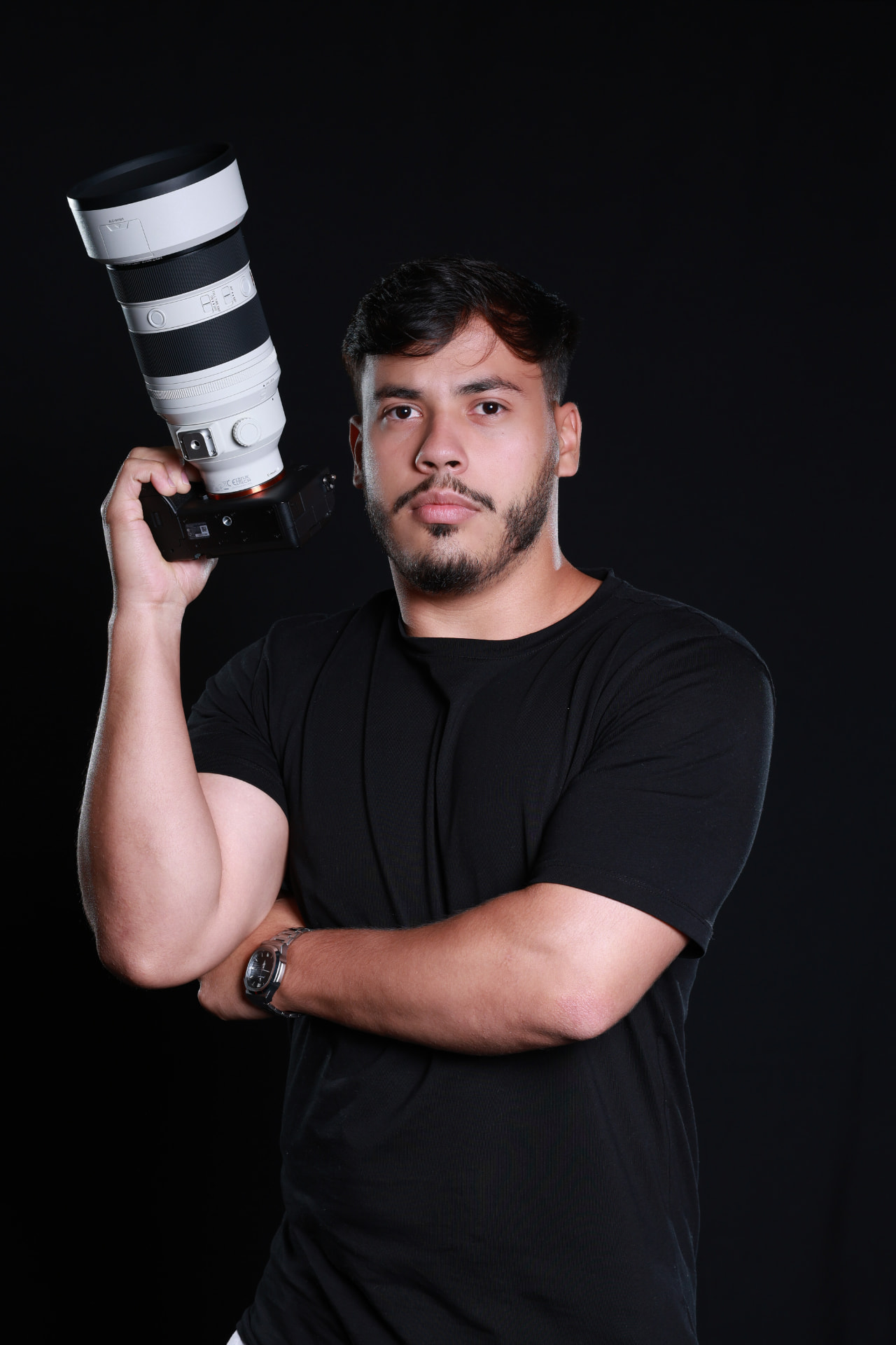 Lucas Praxedes segurando câmera e lente ao lado da cabeça