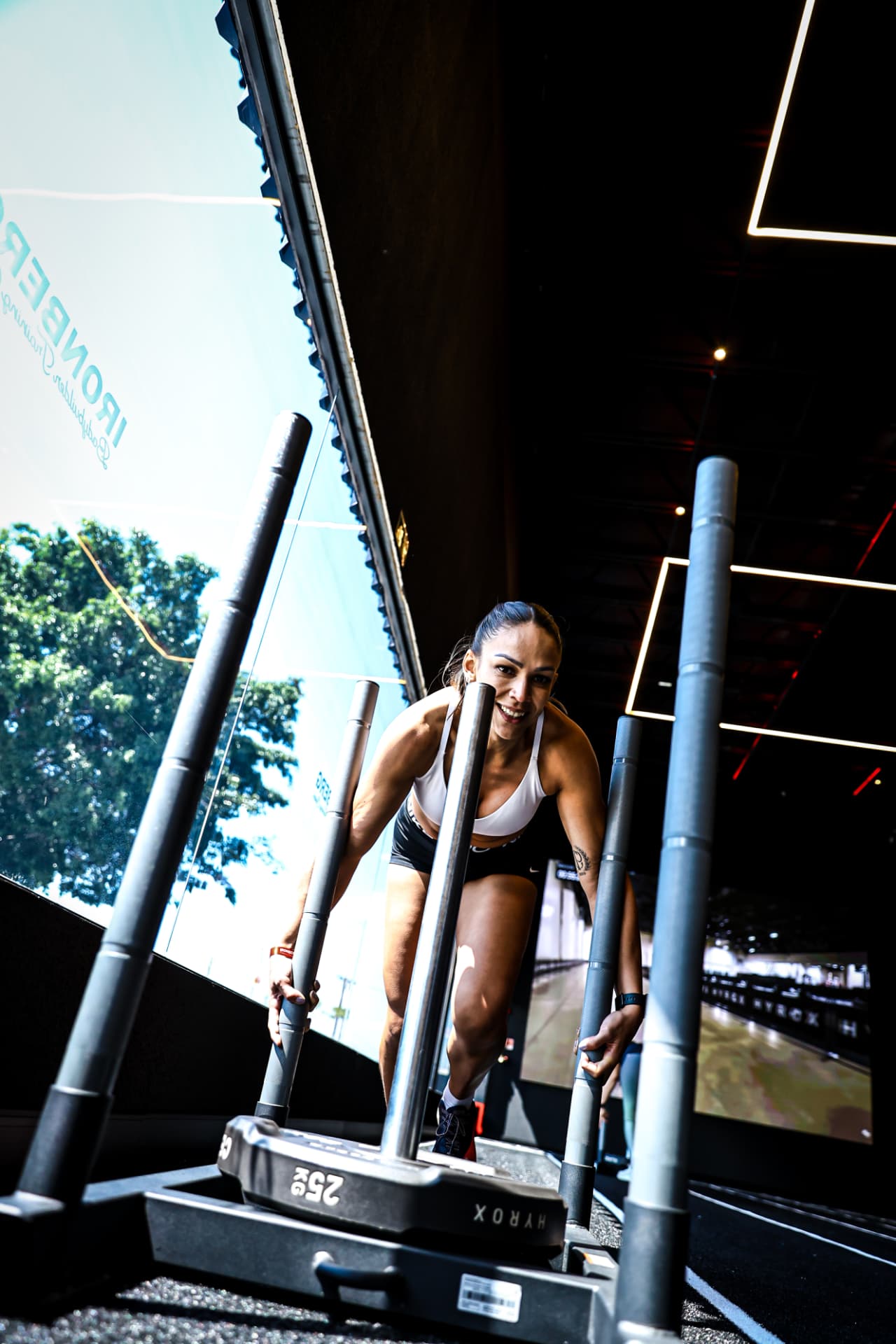 Atleta empurrando o sled Hyrox sorrindo